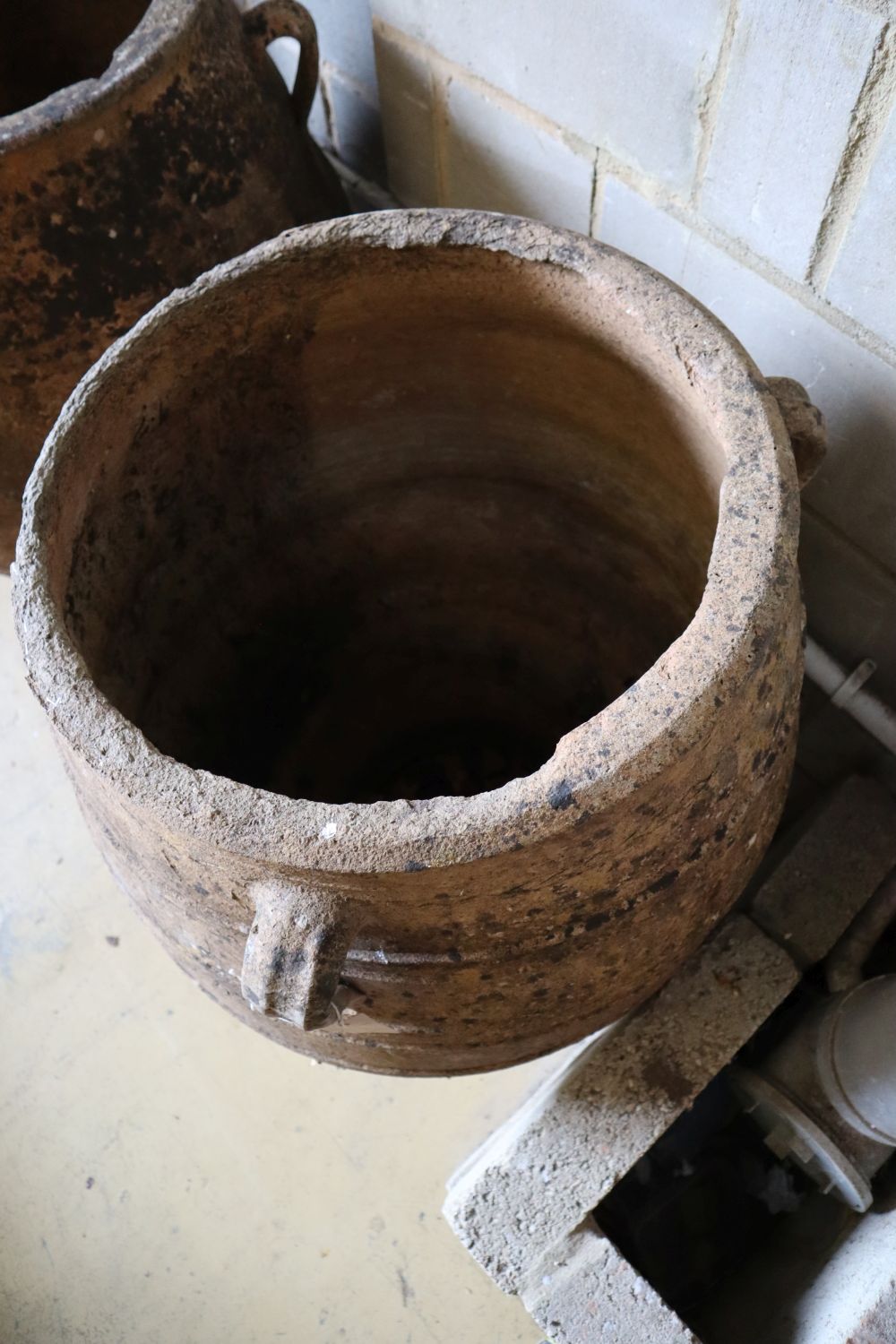 A pair of three-handled terracotta oil jars, each with ribbed sides and narrow foot, height 100cm (faults)